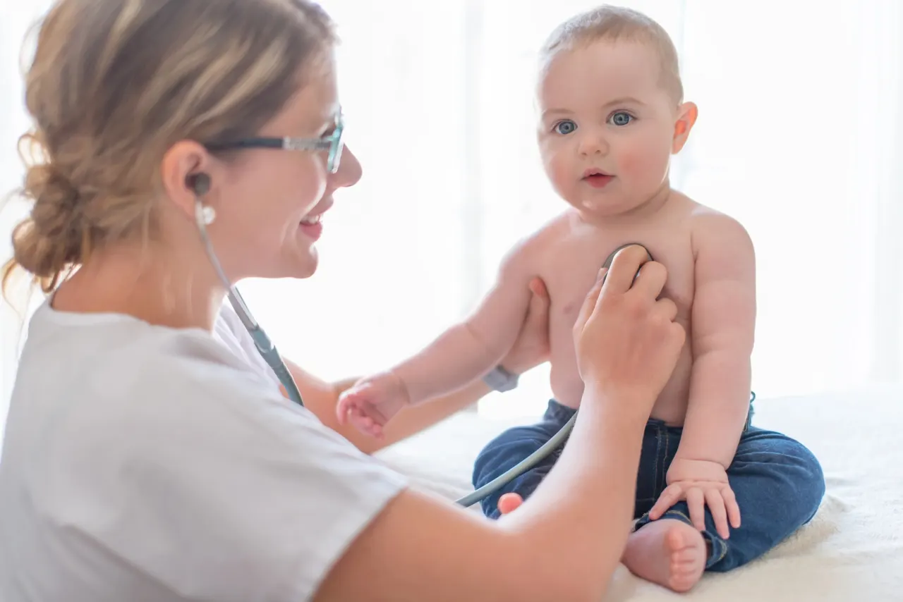 A doctor listening to a baby's chest